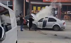Otomobilde çıkan yangını esnaf söndürdü