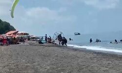 Sahilde motorlu yamaç paraşütüyle havalanırken tatilcilerin arasına daldı