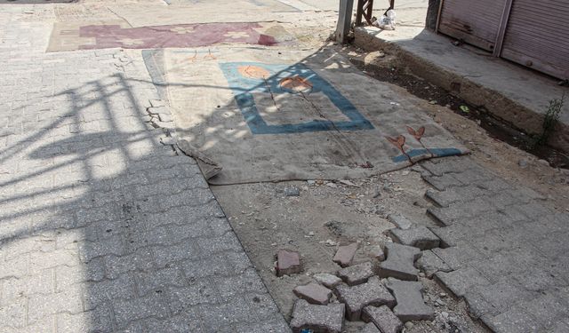 Mahalleli, onarılmayan yollara tozdan korunmak için halı serdi