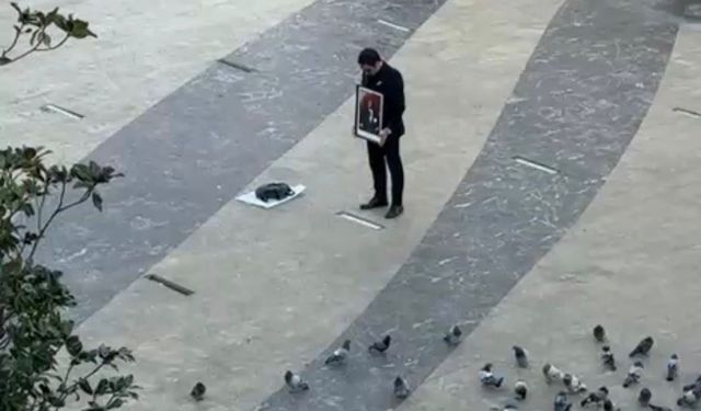 Elinde Atatürk tablosu ile saygı duruşunda bulundu