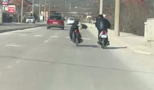 Kasksız sürücünün motosikleti yüzüstü yatarak kullandığı anlar kamerada