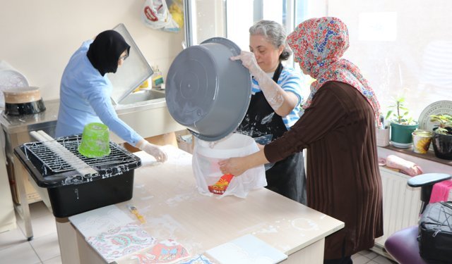 Kazanın izlerini çini fırçasıyla siliyor