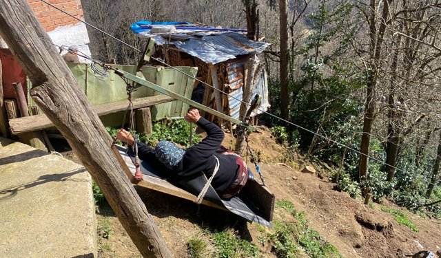 Yol olmayan eve çelik tel üzerinde tehlikeli yolculuk