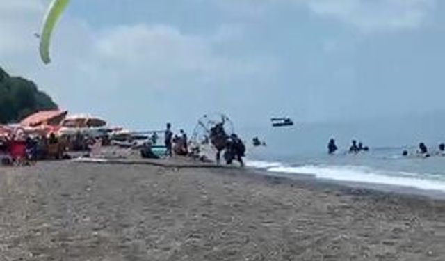 Sahilde motorlu yamaç paraşütüyle havalanırken tatilcilerin arasına daldı